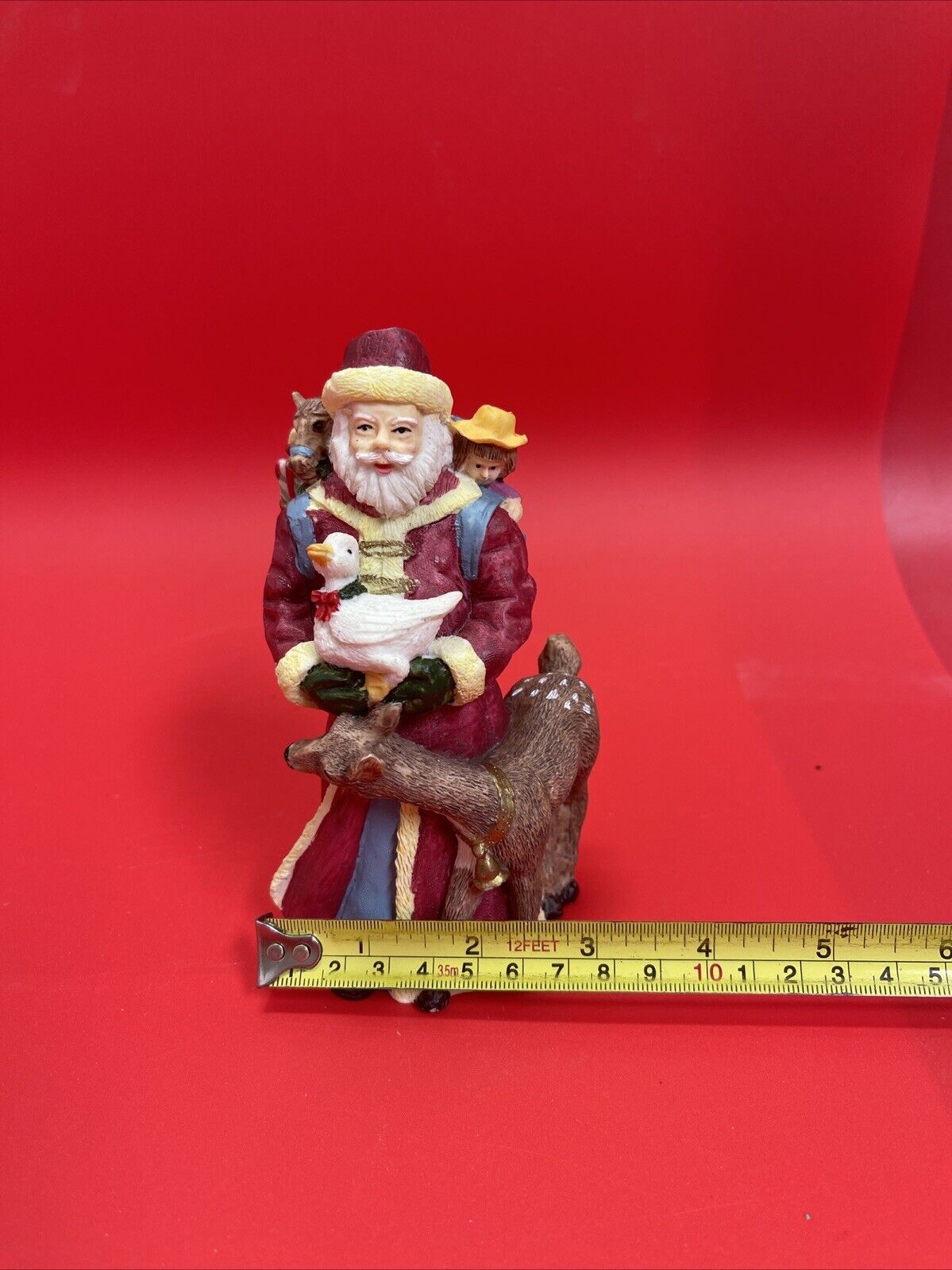 Santa Claus figurine with reindeer, duck and bag of gifts