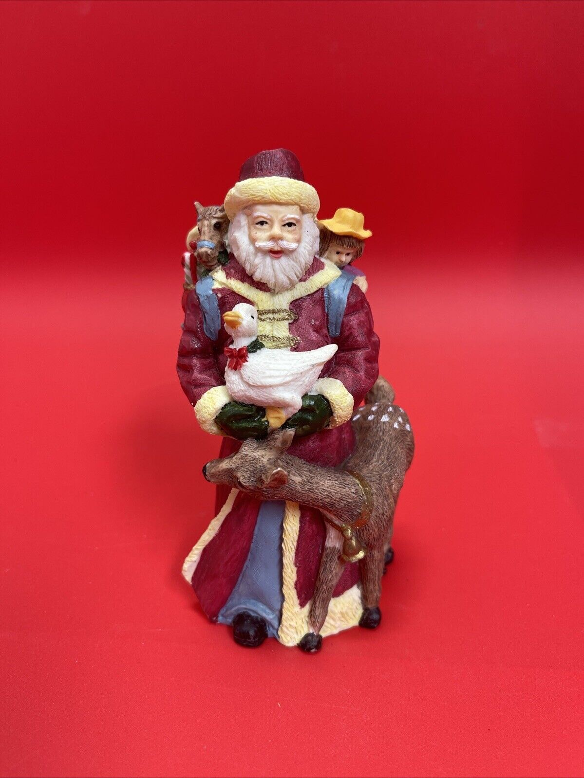 Santa Claus figurine with reindeer, duck and bag of gifts