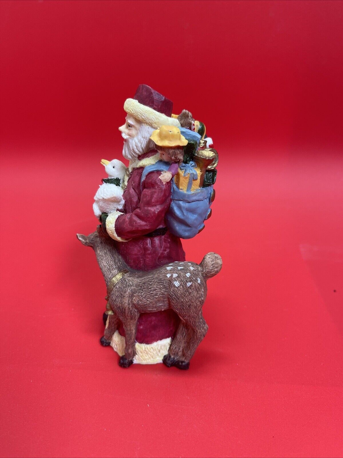 Santa Claus figurine with reindeer, duck and bag of gifts