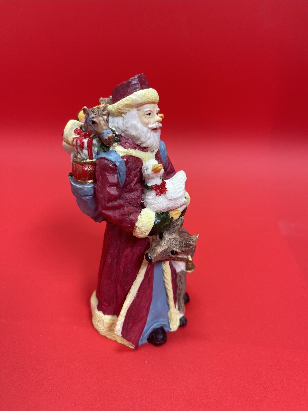 Santa Claus figurine with reindeer, duck and bag of gifts