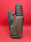 Vintage An ancient folk wood carving depicting a seated figure with a bird.