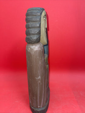 Vintage An ancient folk wood carving depicting a seated figure with a bird.